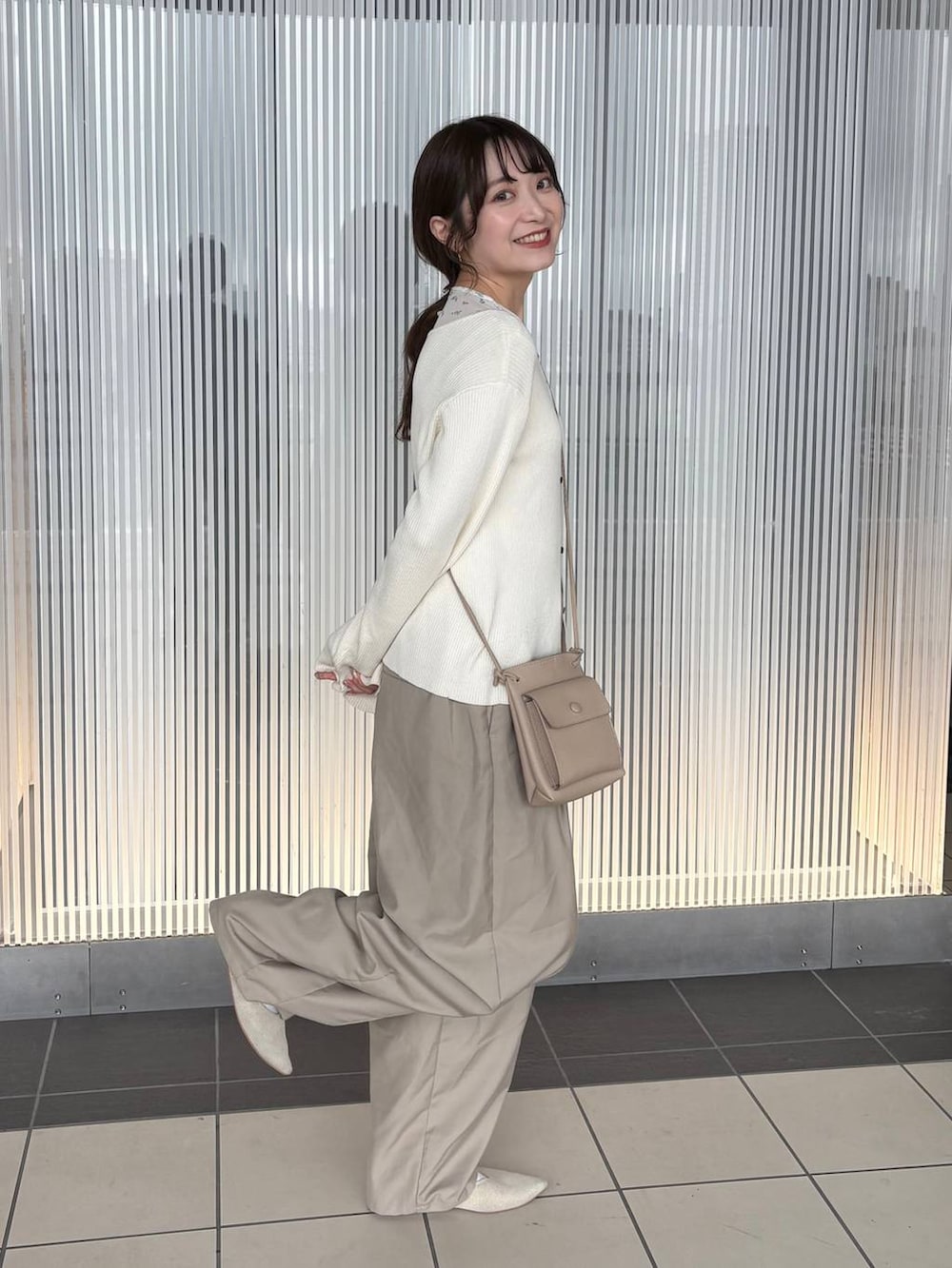 ホワイト系のニット/セーター、ベージュ系のその他パンツ、ホワイト系のTシャツ/カットソーを着用したレディースの春コーディネートの6枚目の写真