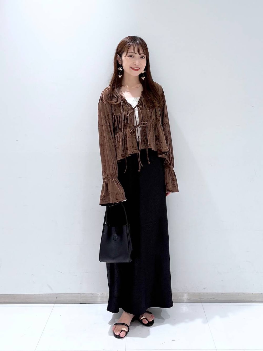 ブラック系のスカート、ブラック系のサンダル、ブラック系のショルダーバッグを着用したレディースの夏コーディネートの2枚目の写真