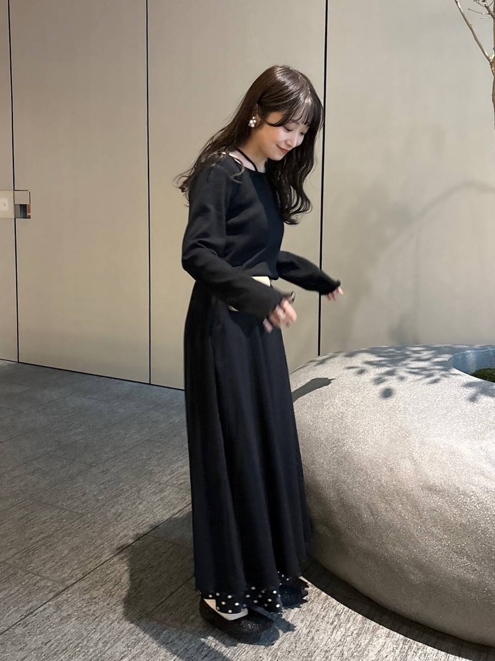 ブラック系のスカート、ベージュ系のボディバッグ/ウエストポーチ、ブラック系のパンプスを着用したレディースの春コーディネートの2枚目の写真