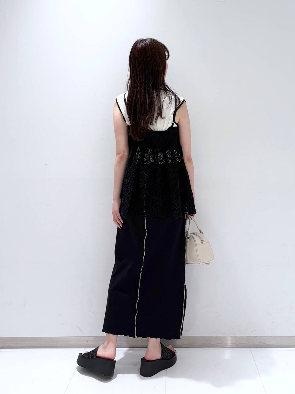 ブラック系のサンダル、ブラック系のキャミソール、ホワイト系のショルダーバッグを着用したレディースの夏コーディネートの5枚目の写真