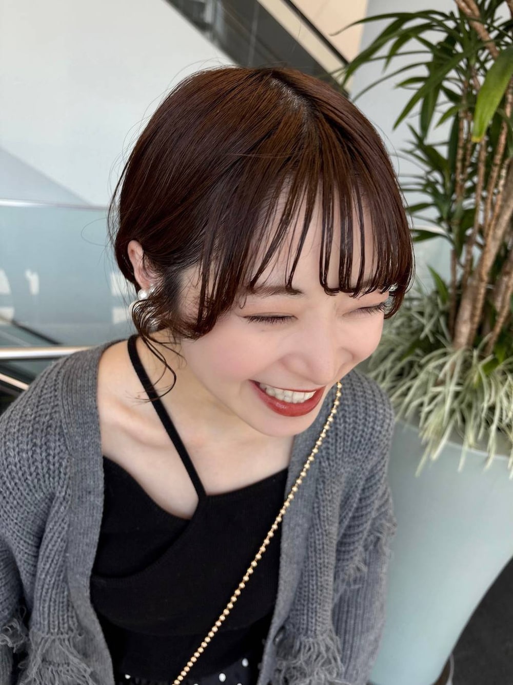 ゴールド系のショルダーバッグ、ブラック系のスカートを着用したレディースの春コーディネートの4枚目の写真