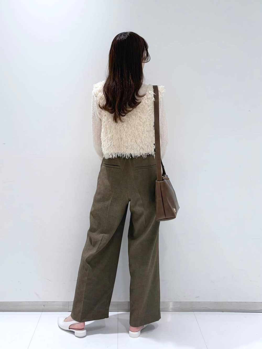 ブラウン系のスラックス、ホワイト系のパンプス、ホワイト系のTシャツ/カットソーを着用したレディースの春コーディネートの4枚目の写真