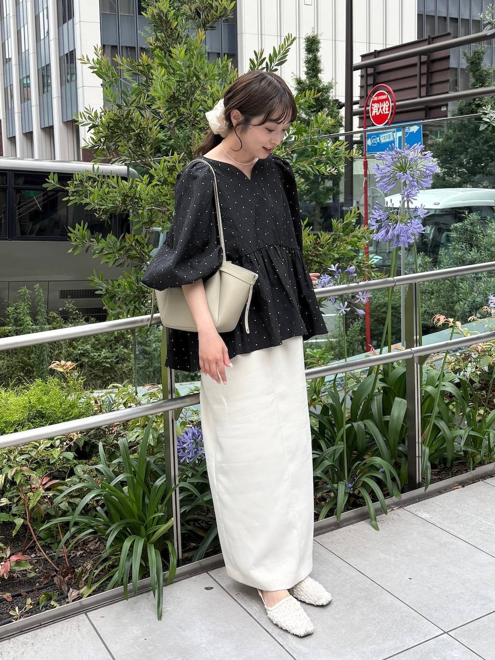 ホワイト系のパンプス、ホワイト系のネックレスを着用したレディースの夏コーディネートの2枚目の写真