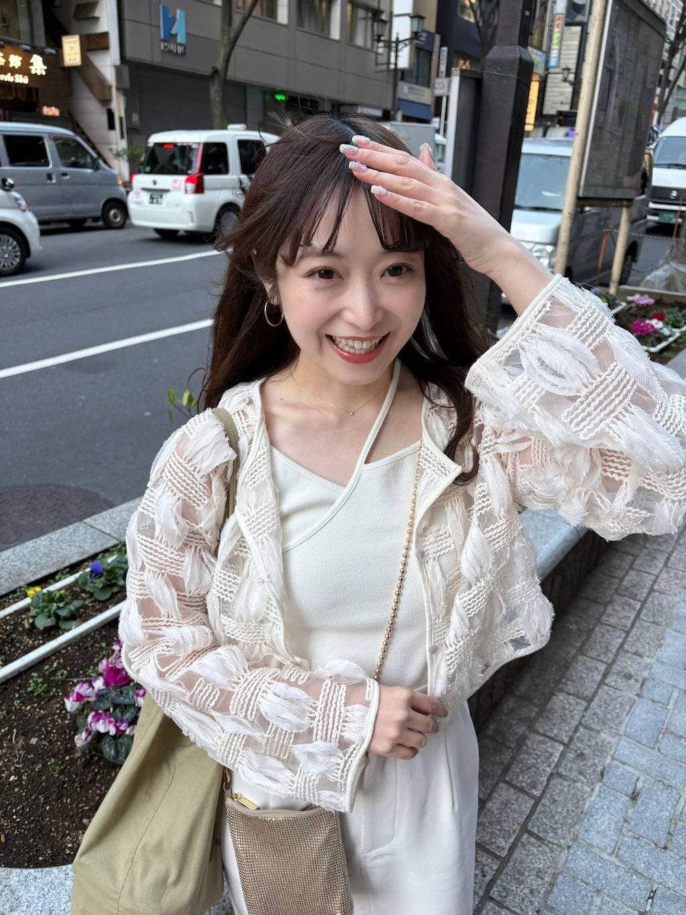 ゴールド系のショルダーバッグ、ホワイト系のパンプスを着用したレディースの春コーディネートの4枚目の写真