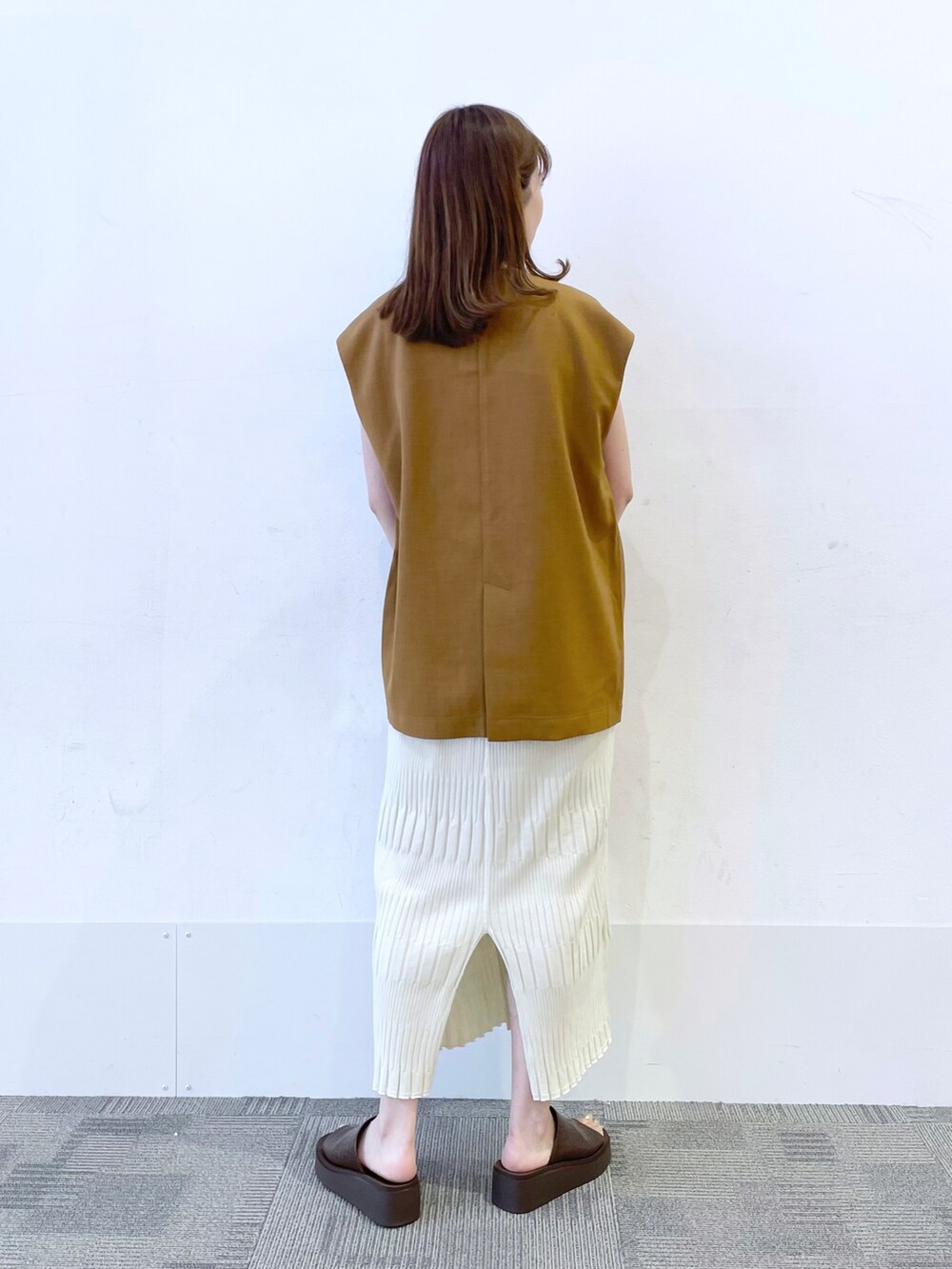 ブラウン系のサンダル、ホワイト系のショルダーバッグ、ホワイト系のワンピースを着用したレディースの夏コーディネートの2枚目の写真