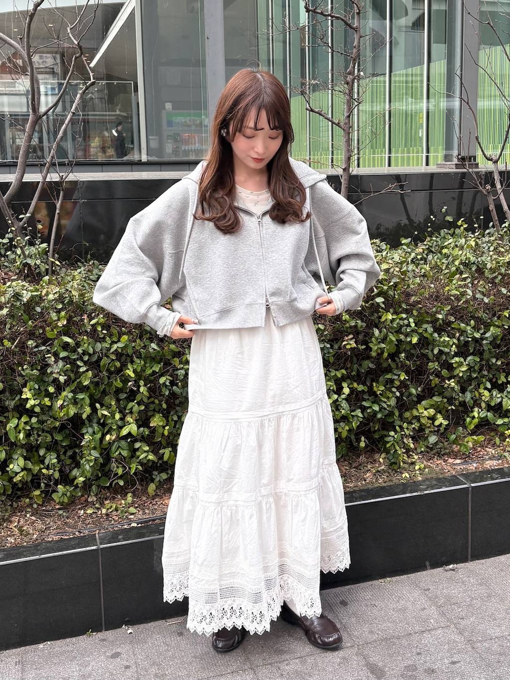 グレー系のパーカー、ホワイト系のTシャツ/カットソー、ブラウン系のローファーを着用したレディースの冬コーディネートの5枚目の写真