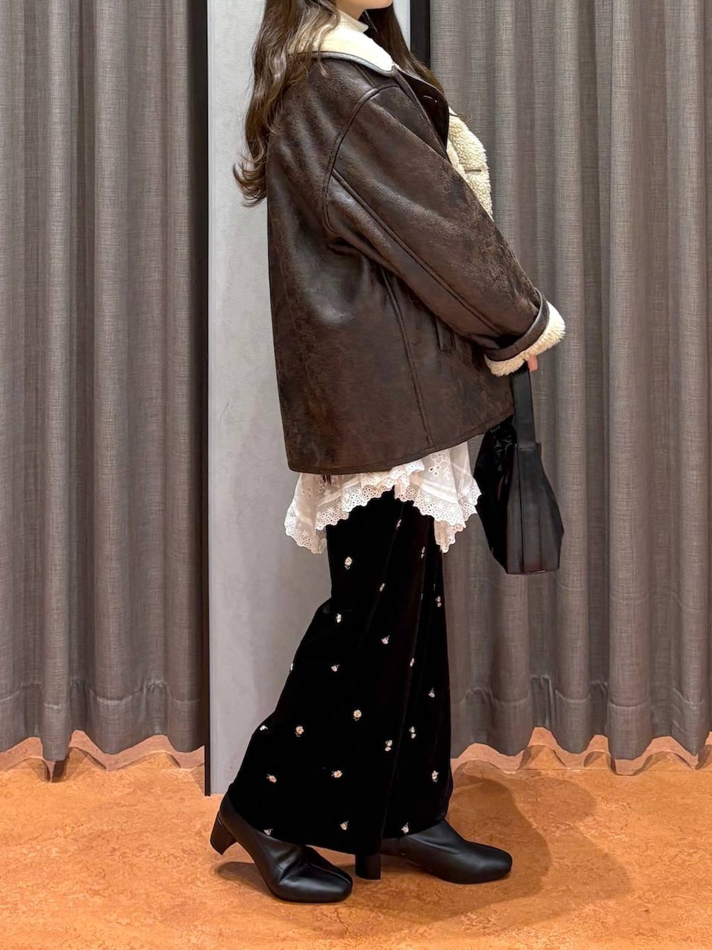 ブラウン系のニット/セーター、ホワイト系のニット/セーター、ブラウン系のムートンコートを着用したレディースの冬コーディネートの3枚目の写真