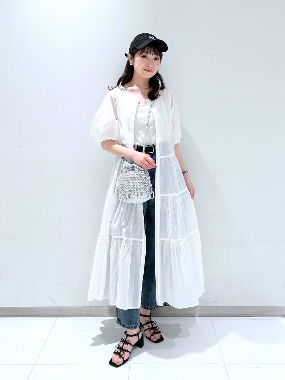 ホワイト系のTシャツ/カットソー、ブラック系のサンダル、ブルー系のデニムパンツを着用したレディースの春コーディネートの2枚目の写真