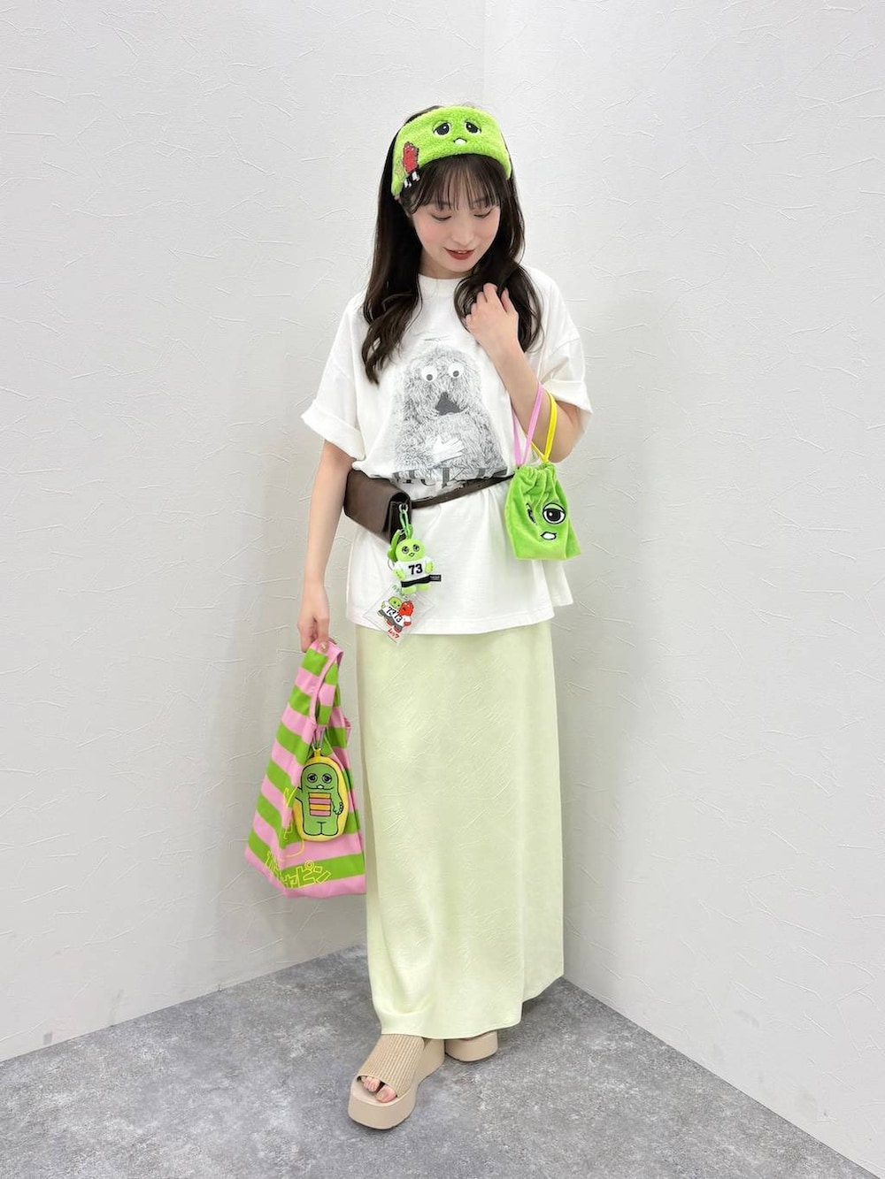 グリーン系のスカート、ホワイト系のサンダル、その他のエコバッグ/サブバッグを着用したレディースの春コーディネートの2枚目の写真