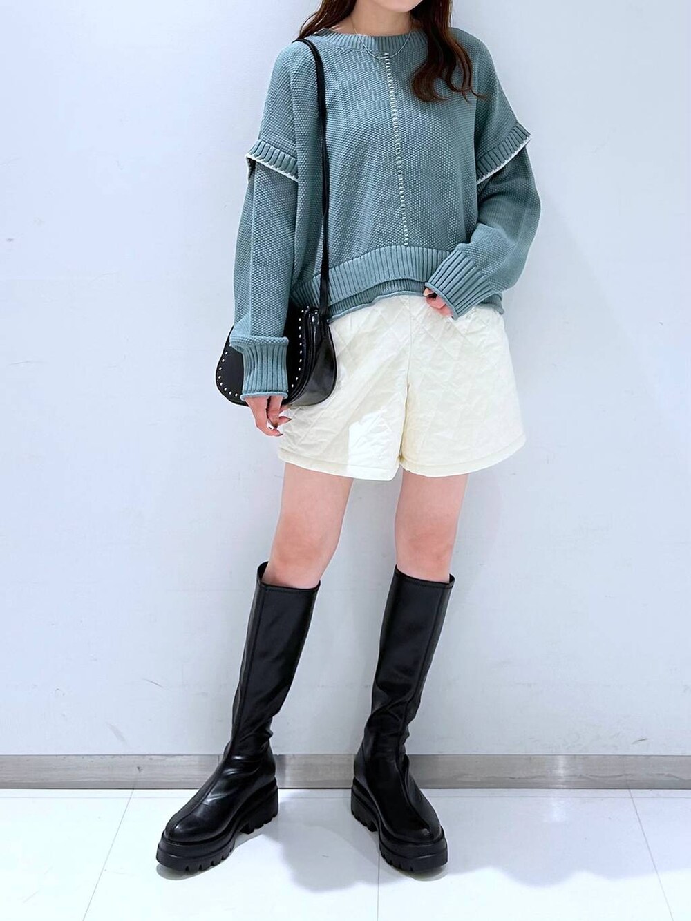 グリーン系のニット/セーター、ホワイト系のその他パンツ、ブラック系のショルダーバッグを着用したレディースの秋コーディネートの4枚目の写真