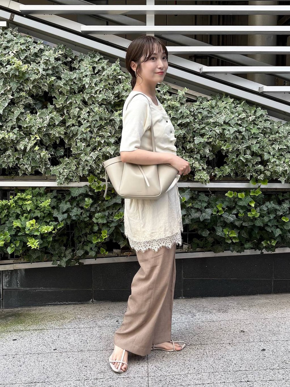 ベージュ系のスラックス、ホワイト系のカーディガン/ボレロ、ホワイト系のワンピースを着用したレディースの夏コーディネートの3枚目の写真