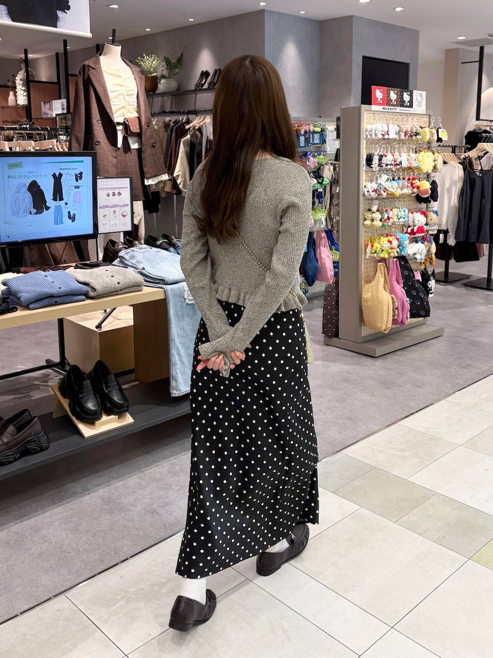 ゴールド系のショルダーバッグ、グレー系のカーディガン/ボレロ、ブラウン系のローファーを着用したレディースの秋コーディネートの6枚目の写真