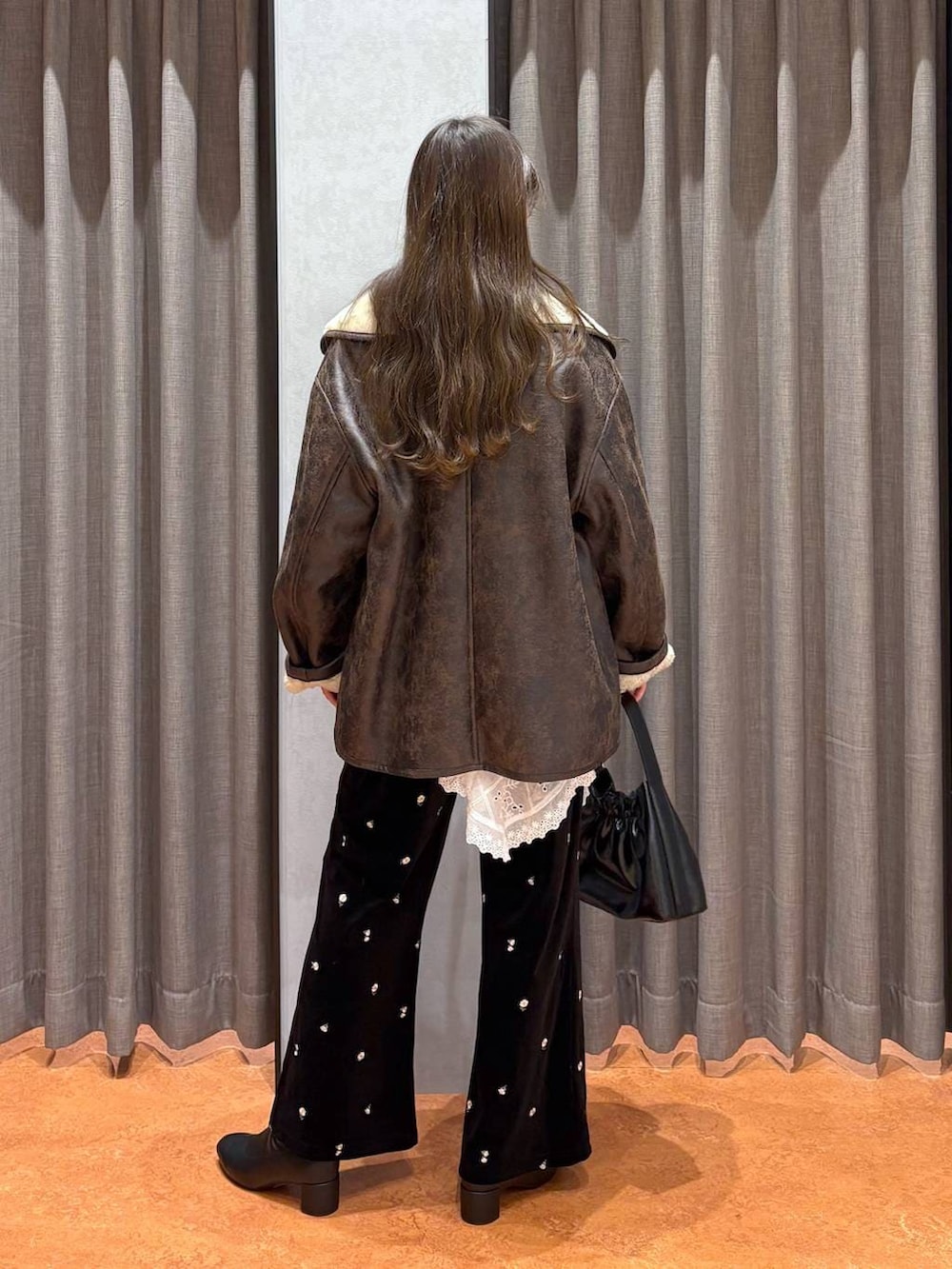 ブラウン系のニット/セーター、ホワイト系のニット/セーター、ブラウン系のムートンコートを着用したレディースの冬コーディネートの4枚目の写真