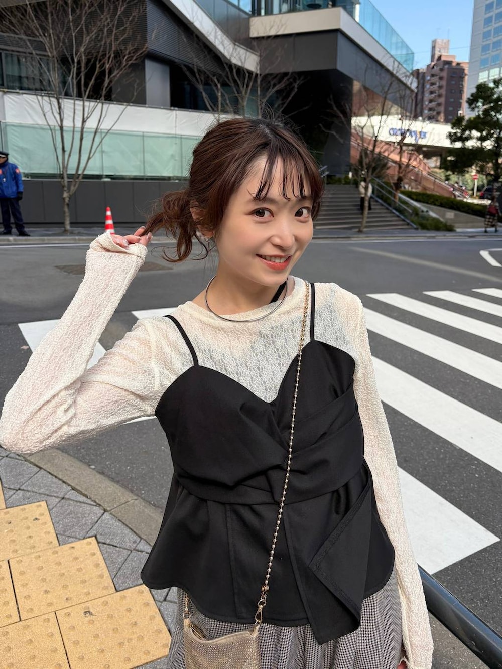 ゴールド系のショルダーバッグ、ブラック系のパンプス、ゴールド系のチョーカーを着用したレディースの春コーディネートの2枚目の写真