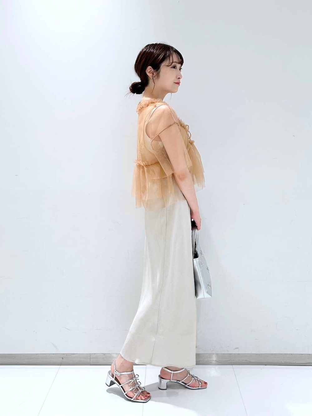 シルバー系のサンダル、ホワイト系のタンクトップ、ホワイト系のスカートを着用したレディースの夏コーディネートの4枚目の写真