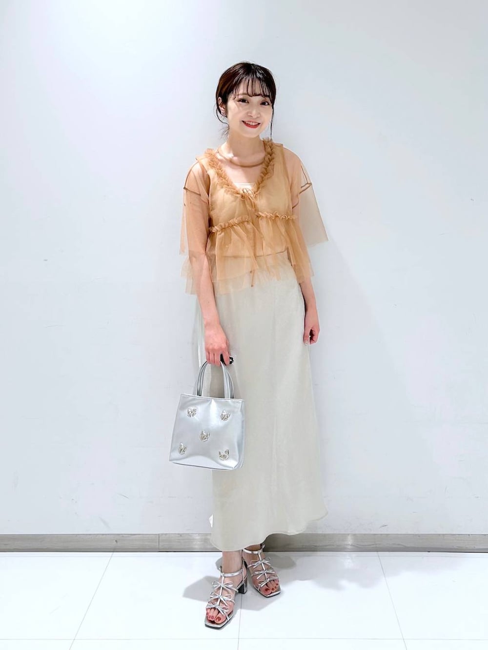 シルバー系のサンダル、ホワイト系のタンクトップ、ホワイト系のスカートを着用したレディースの夏コーディネートの2枚目の写真