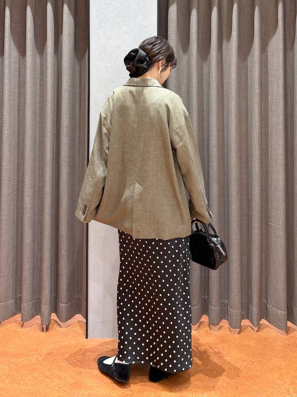 ブラック系のスカート、ブラック系のボストンバッグ、ホワイト系のTシャツ/カットソーを着用したレディースの冬コーディネートの3枚目の写真