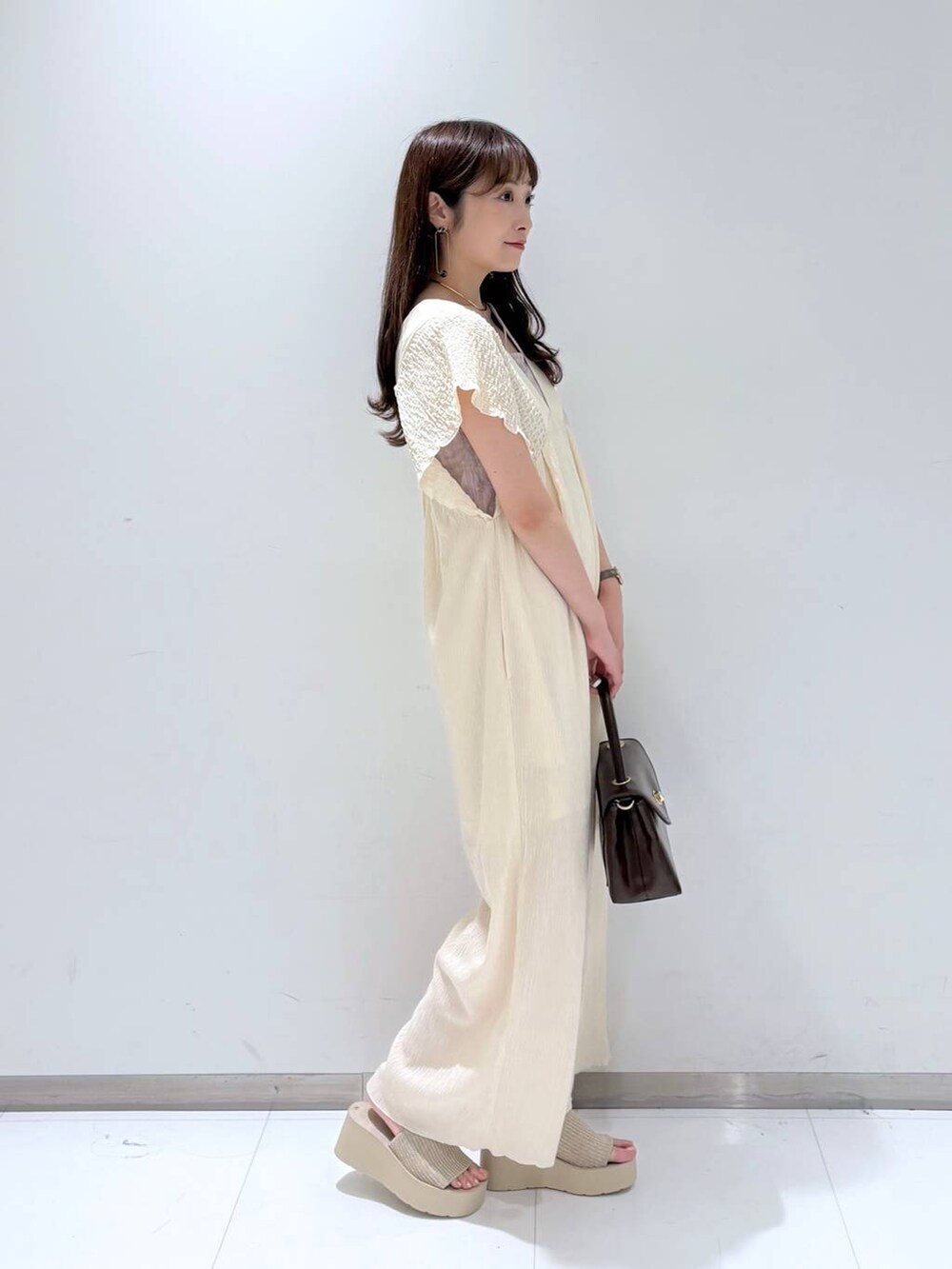 ホワイト系のサンダル、ホワイト系のサロペット/オーバーオール、ブラウン系のボストンバッグを着用したレディースの夏コーディネートの5枚目の写真