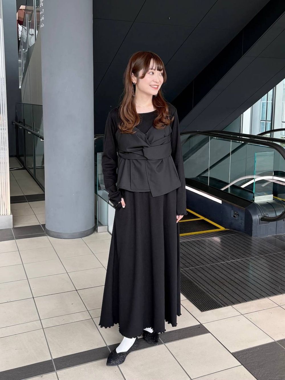 ブラック系のパンプスを着用したレディースの春コーディネートの6枚目の写真