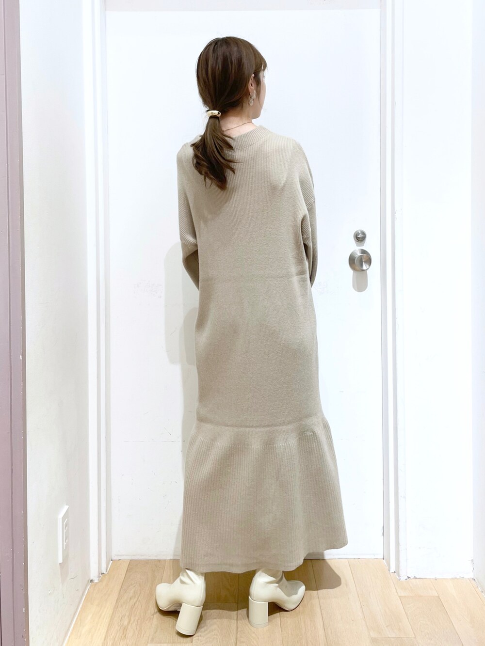 ホワイト系のブルゾン、ホワイト系のワンピース、ホワイト系のブーツを着用したレディースの秋コーディネートの5枚目の写真