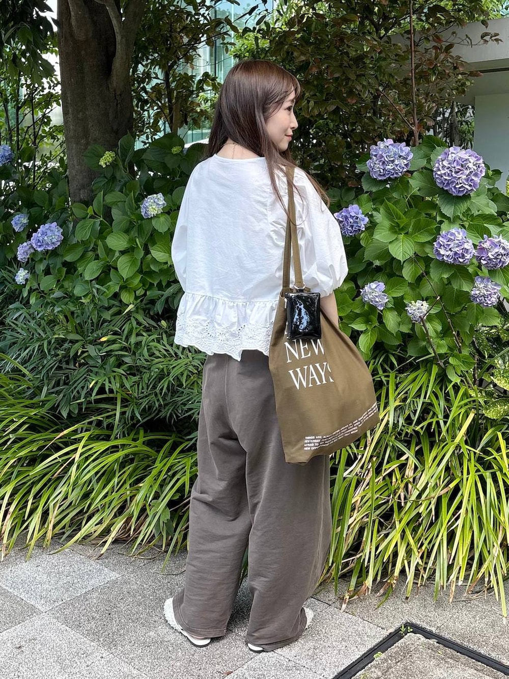 ホワイト系のパンプス、ホワイト系のシャツ/ブラウス、ゴールド系のチョーカーを着用したレディースの夏コーディネートの4枚目の写真