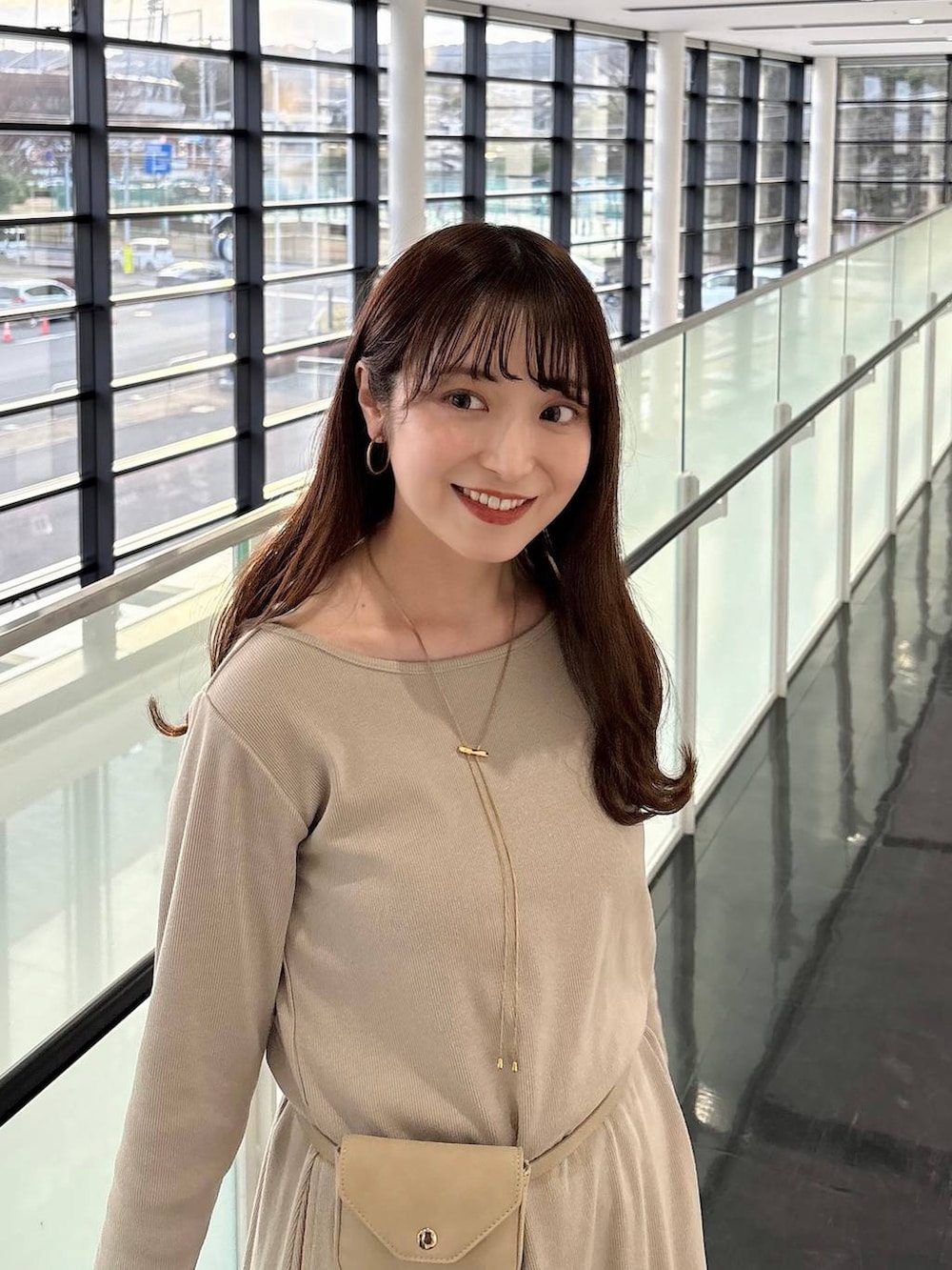 ベージュ系のボディバッグ/ウエストポーチ、ゴールド系のネックレスを着用したレディースの春コーディネートの5枚目の写真