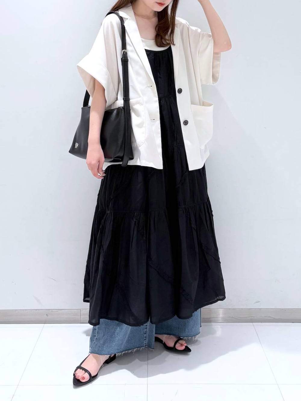 ホワイト系のTシャツ/カットソー、ブラック系のサンダル、ブルー系のデニムパンツを着用したレディースの春コーディネートの2枚目の写真