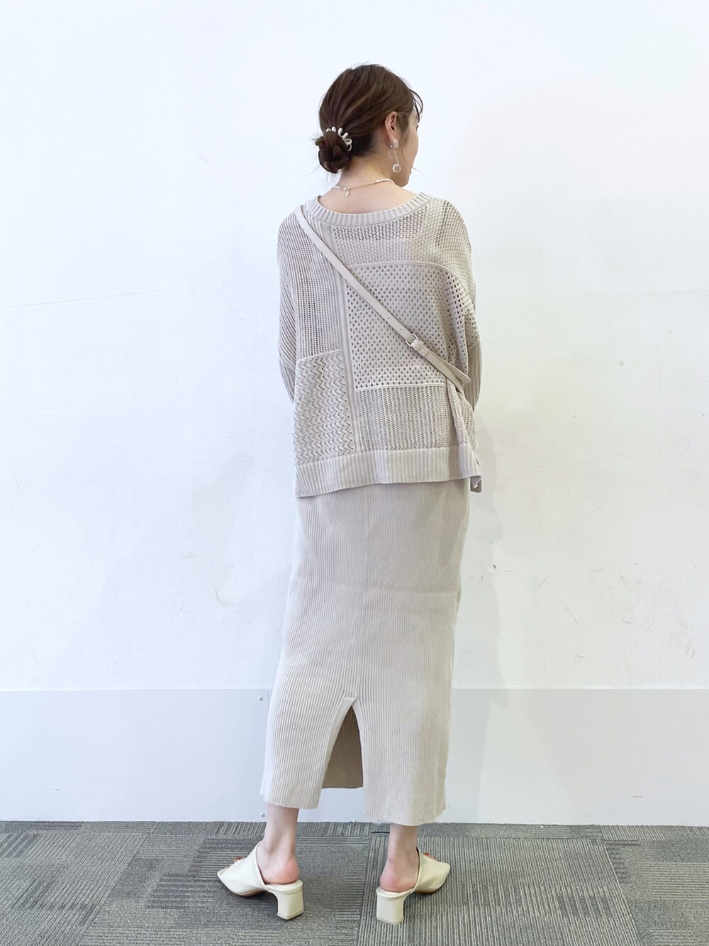 ベージュ系のワンピース、ホワイト系のサンダル、ホワイト系のショルダーバッグを着用したレディースの春コーディネートの2枚目の写真