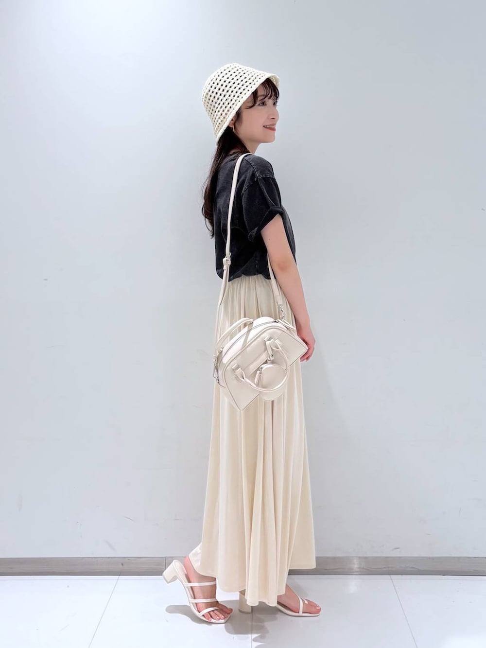 ホワイト系のサンダル、ホワイト系のショルダーバッグ、ホワイト系のスカートを着用したレディースの夏コーディネートの4枚目の写真