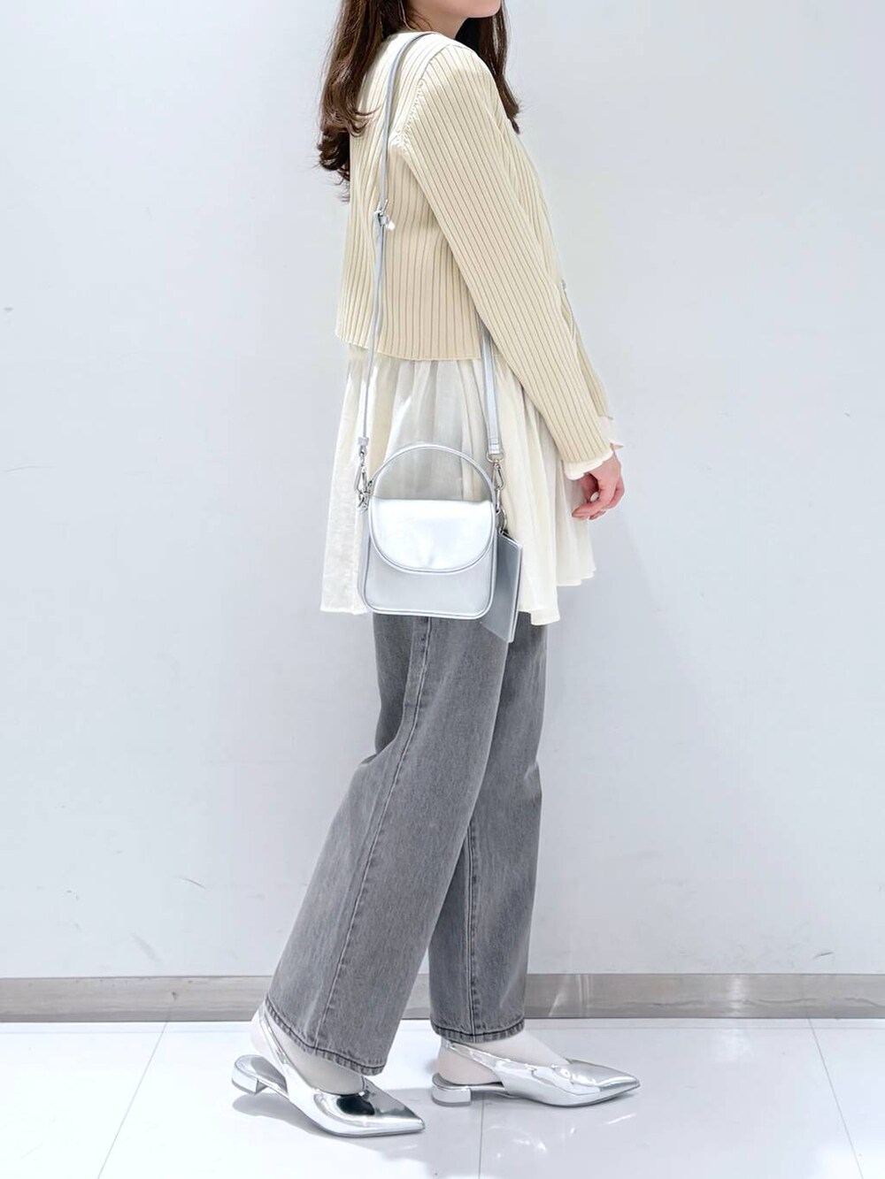 ホワイト系のシャツ/ブラウス、ホワイト系のカーディガン/ボレロ、グレー系のデニムパンツを着用したレディースの春コーディネートの2枚目の写真