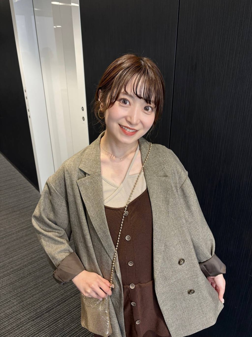 ゴールド系のショルダーバッグ、ブラウン系のテーラードジャケット、ブラウン系のつなぎ/オールインワンを着用したレディースの春コーディネートの4枚目の写真