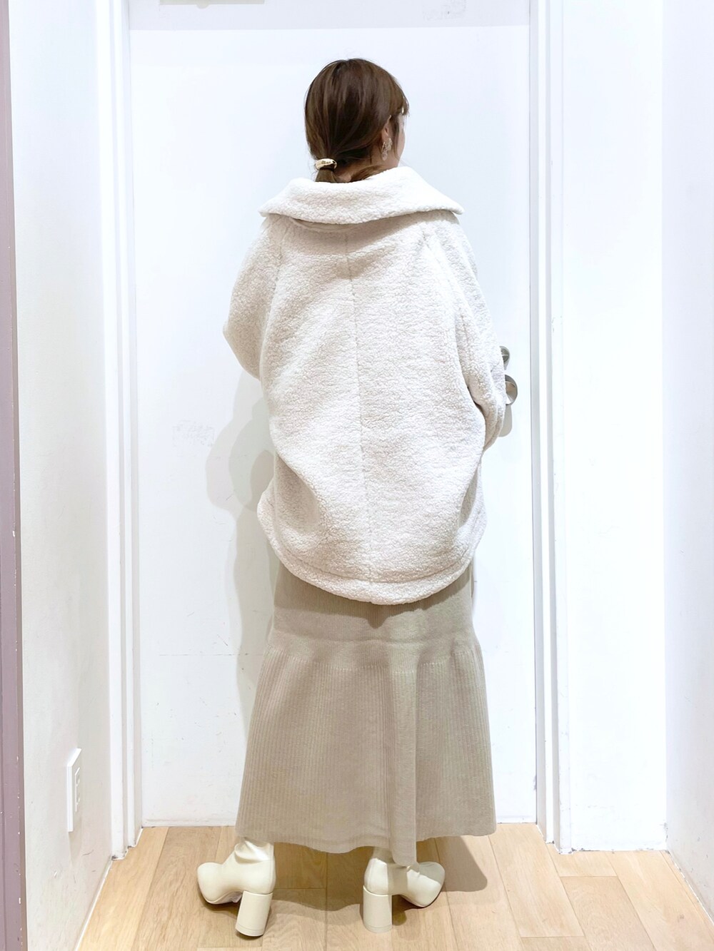 ホワイト系のブルゾン、ホワイト系のワンピース、ホワイト系のブーツを着用したレディースの秋コーディネートの3枚目の写真