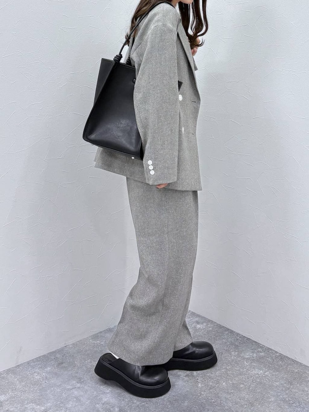 ホワイト系のTシャツ/カットソー、ブラック系のサンダル、グレー系のデニムパンツを着用したレディースの冬コーディネートの3枚目の写真