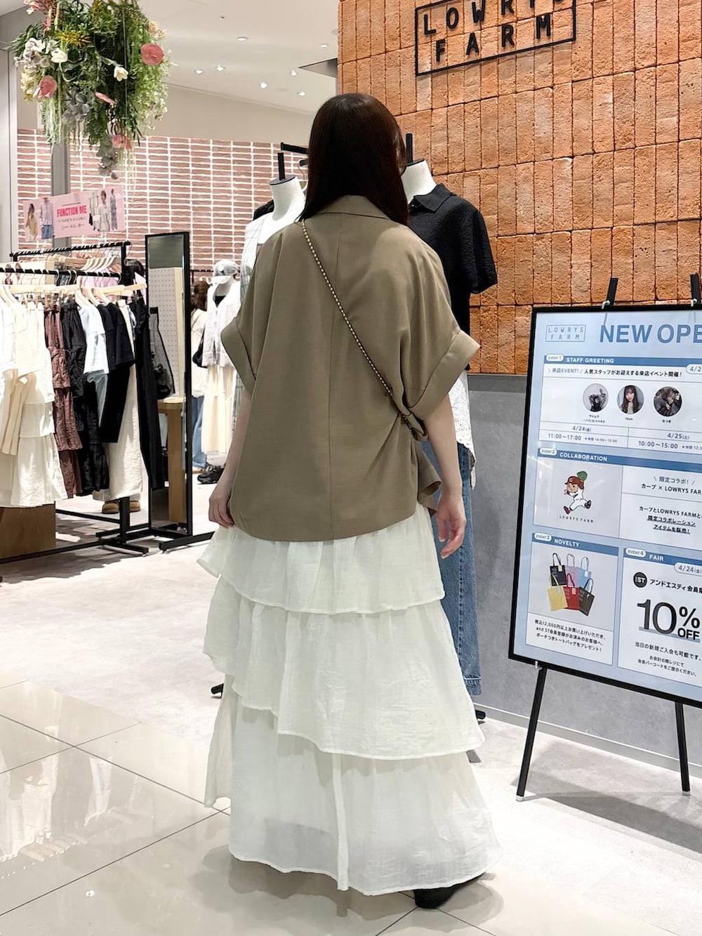 ゴールド系のショルダーバッグ、ゴールド系のタンクトップ、ブラウン系のローファーを着用したレディースの春コーディネートの3枚目の写真