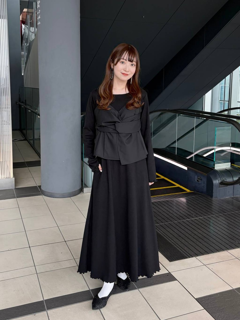 ブラック系のパンプスを着用したレディースの春コーディネートの2枚目の写真