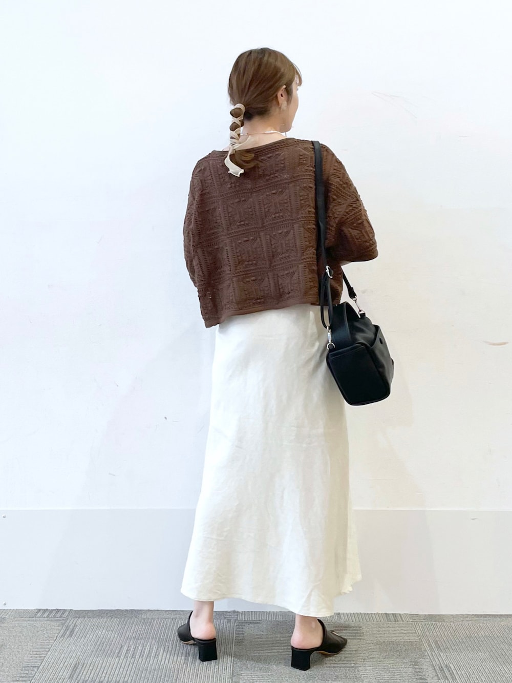 ブラック系のサンダル、ホワイト系のスカート、ブラック系のショルダーバッグを着用したレディースの夏コーディネートの2枚目の写真