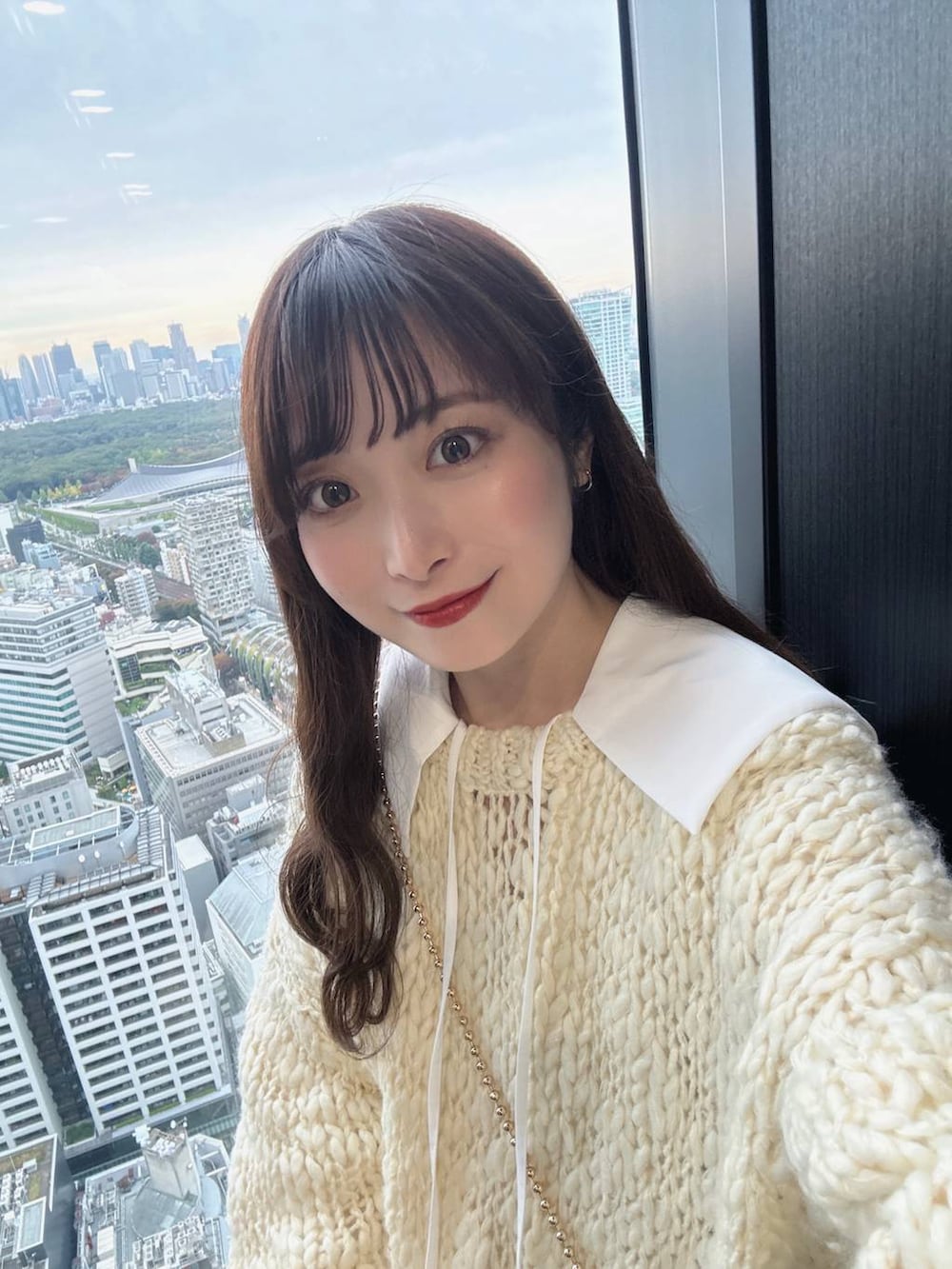 ゴールド系のショルダーバッグ、ホワイト系のニット/セーター、ホワイト系のシャツ/ブラウスを着用したレディースの秋コーディネートの5枚目の写真