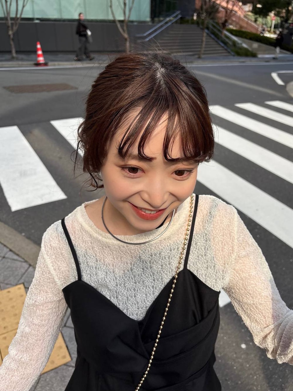 ゴールド系のショルダーバッグ、ブラック系のパンプス、ゴールド系のチョーカーを着用したレディースの春コーディネートの5枚目の写真