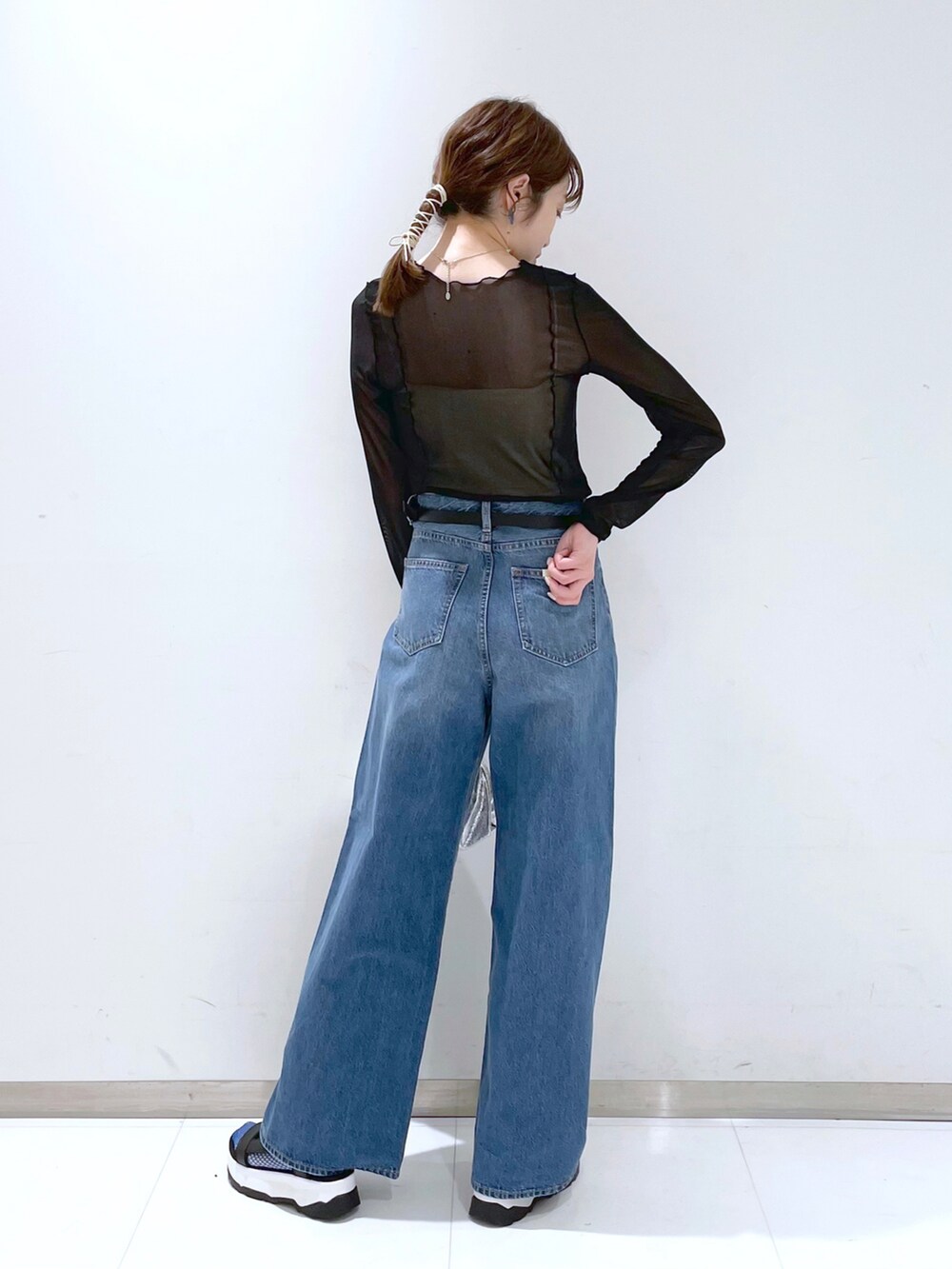 シルバー系のショルダーバッグ、ブルー系のデニムパンツ、ブラック系のキャミソールを着用したレディースの春コーディネートの2枚目の写真