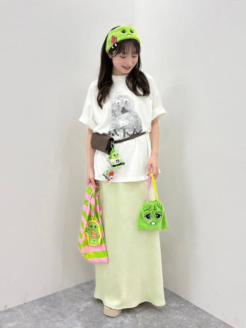 グリーン系のスカート、ホワイト系のサンダル、その他のエコバッグ/サブバッグを着用したレディースの春コーディネートの3枚目の写真