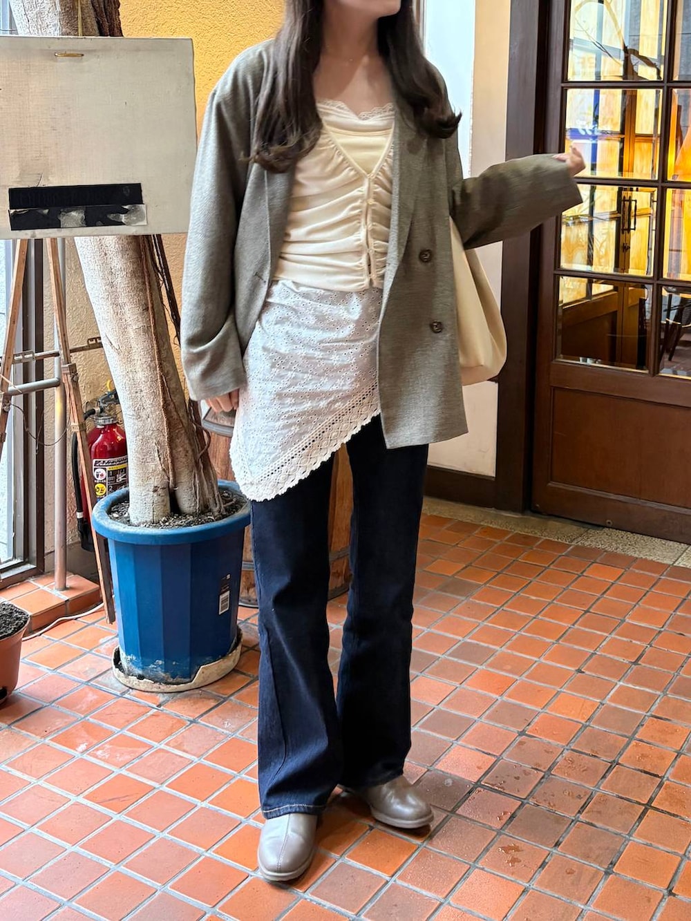 ブラウン系のテーラードジャケット、ホワイト系のキャミソール、ホワイト系のバンダナ/スカーフを着用したレディースの春コーディネートの2枚目の写真