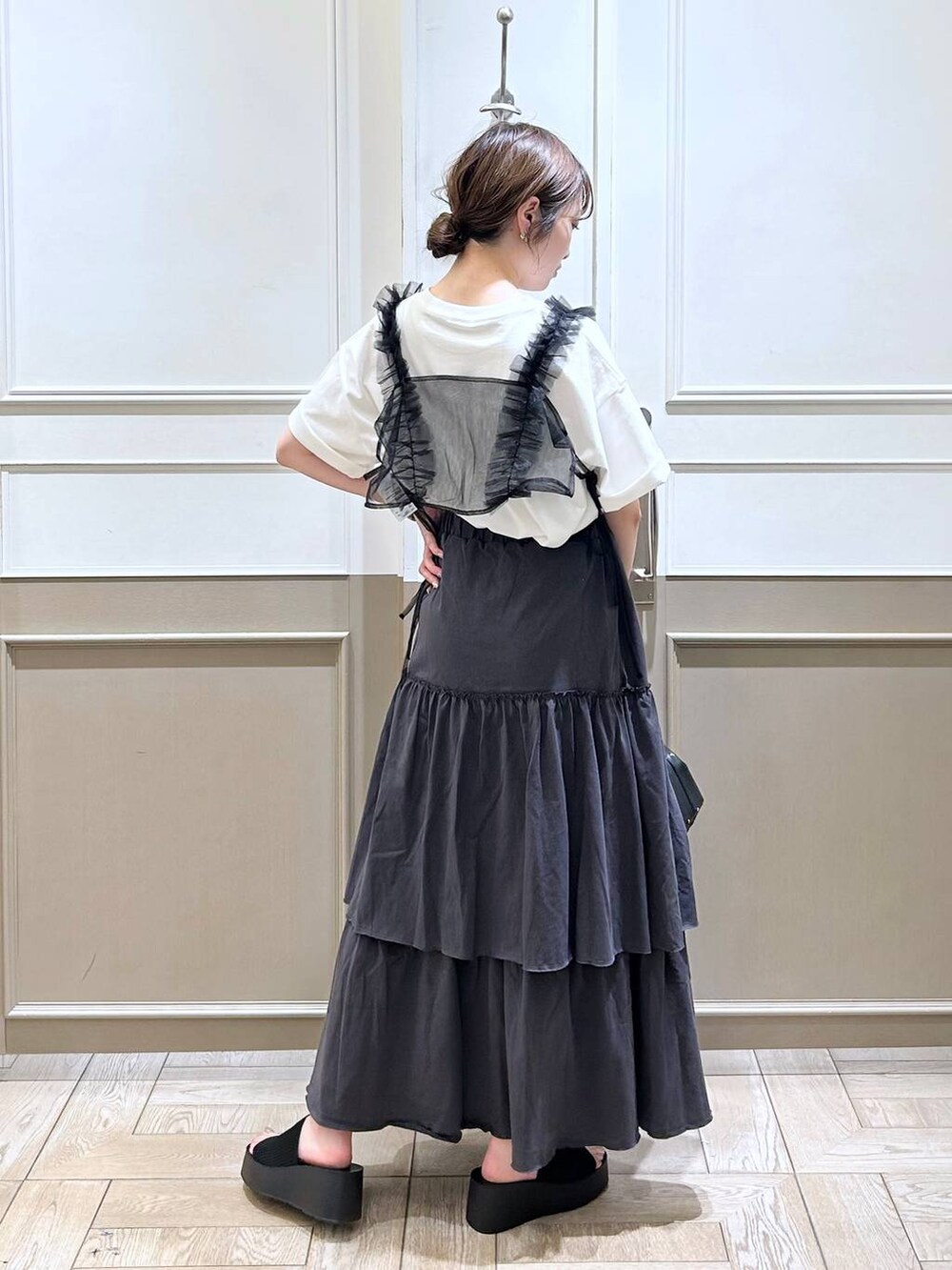 ブラック系のハンドバッグ、ブラック系のサンダル、ブラック系のベストを着用したレディースの夏コーディネートの6枚目の写真