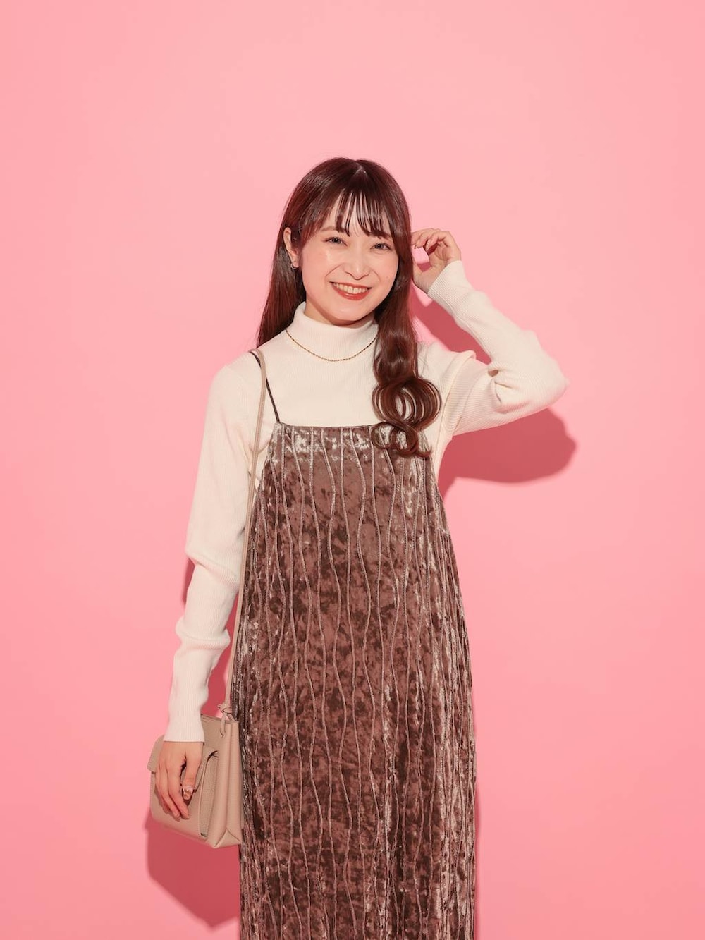 ホワイト系のニット/セーター、ブラウン系のブーツ、ゴールド系のネックレスを着用したレディースの冬コーディネートの4枚目の写真