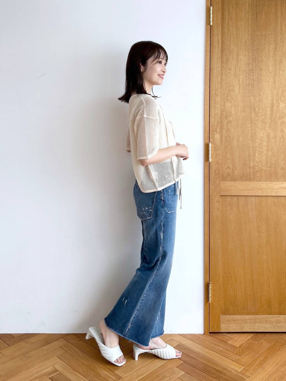 ホワイト系のタンクトップ、その他のデニムパンツ、ホワイト系のサンダルを着用したレディースの秋コーディネートの3枚目の写真