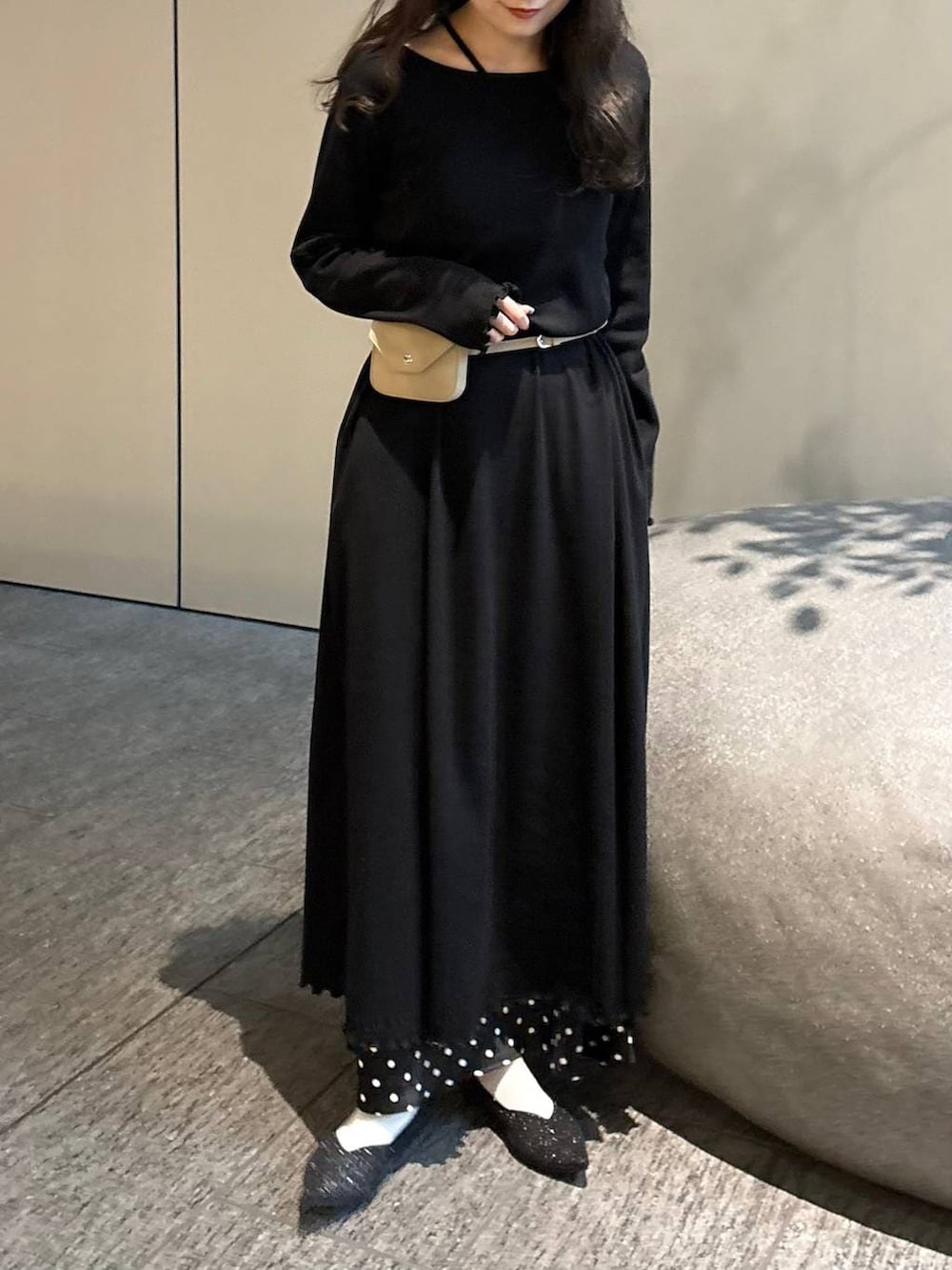 ブラック系のスカート、ベージュ系のボディバッグ/ウエストポーチ、ブラック系のパンプスを着用したレディースの春コーディネートの4枚目の写真