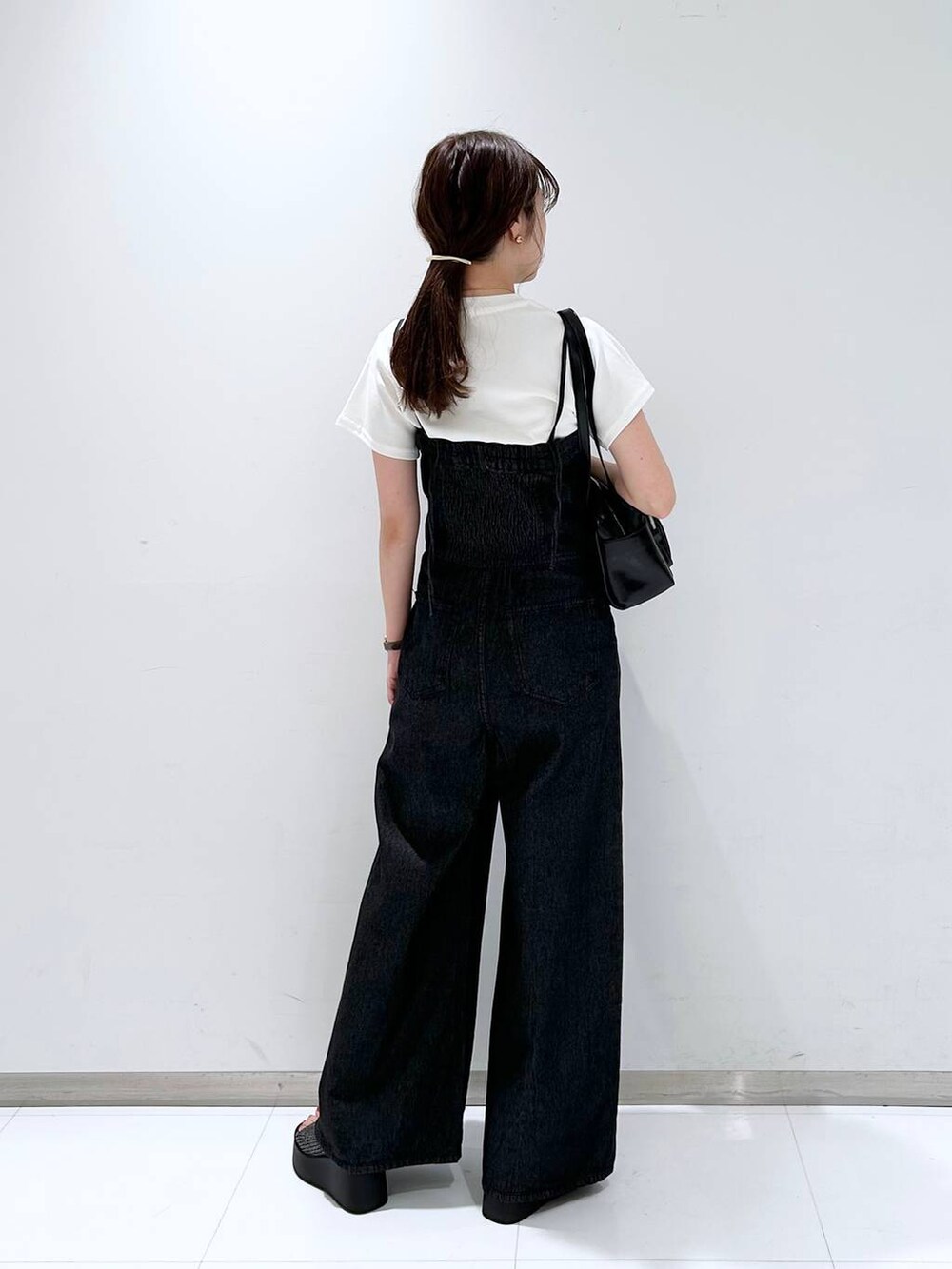 ブラック系のサンダル、ホワイト系のTシャツ/カットソー、ブラック系のボストンバッグを着用したレディースの夏コーディネートの5枚目の写真