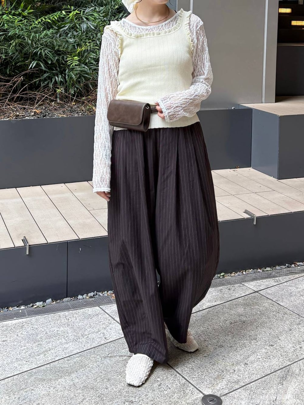 ブラウン系のその他パンツ、ホワイト系のタンクトップ、ブラウン系のボディバッグ/ウエストポーチを着用したレディースの春コーディネートの2枚目の写真