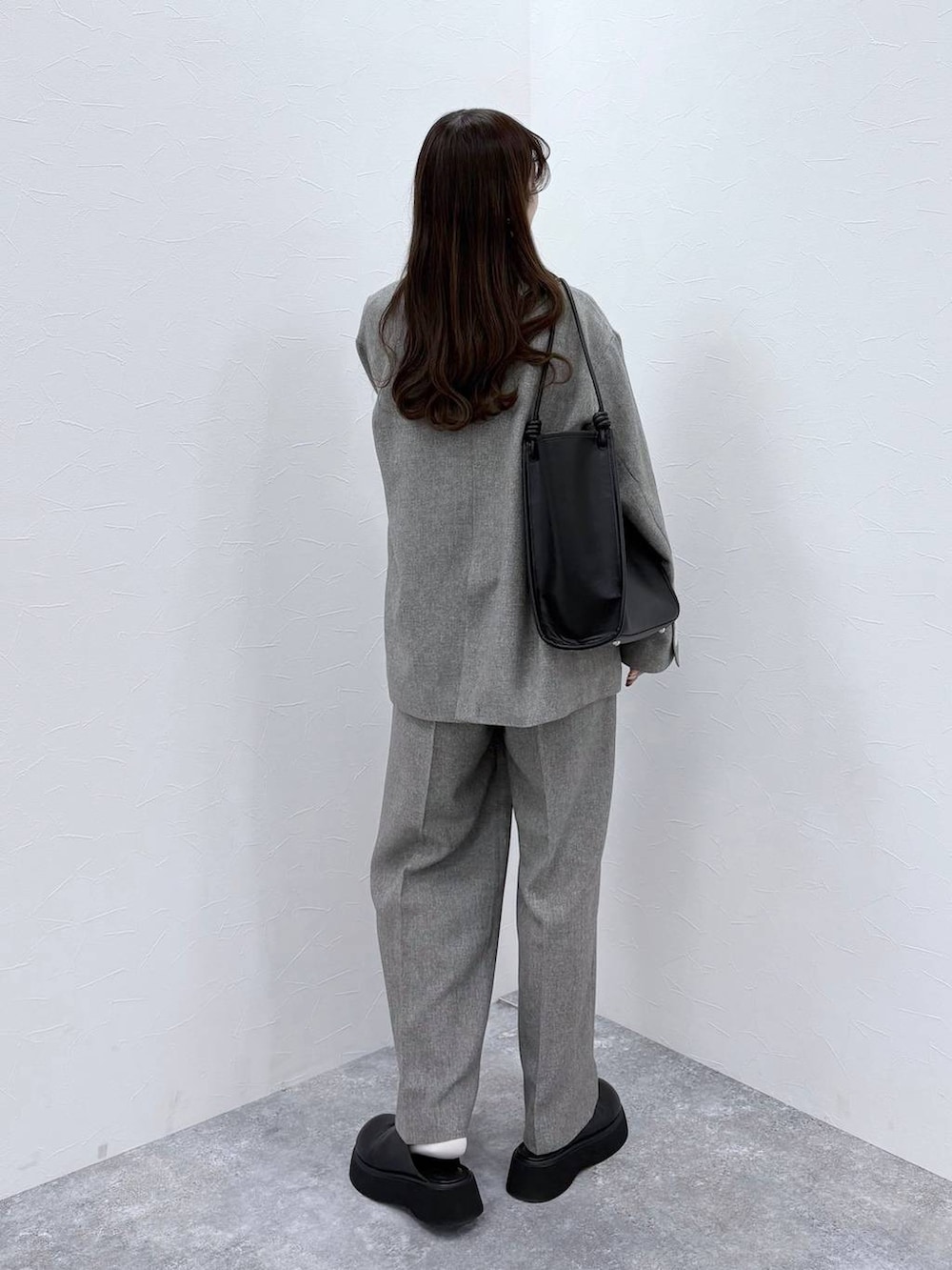 ホワイト系のTシャツ/カットソー、ブラック系のサンダル、グレー系のデニムパンツを着用したレディースの冬コーディネートの4枚目の写真