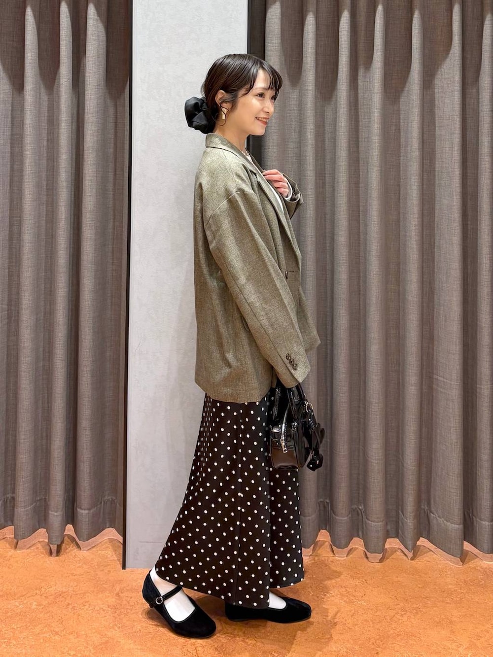 ブラック系のスカート、ブラック系のボストンバッグ、ホワイト系のTシャツ/カットソーを着用したレディースの冬コーディネートの2枚目の写真