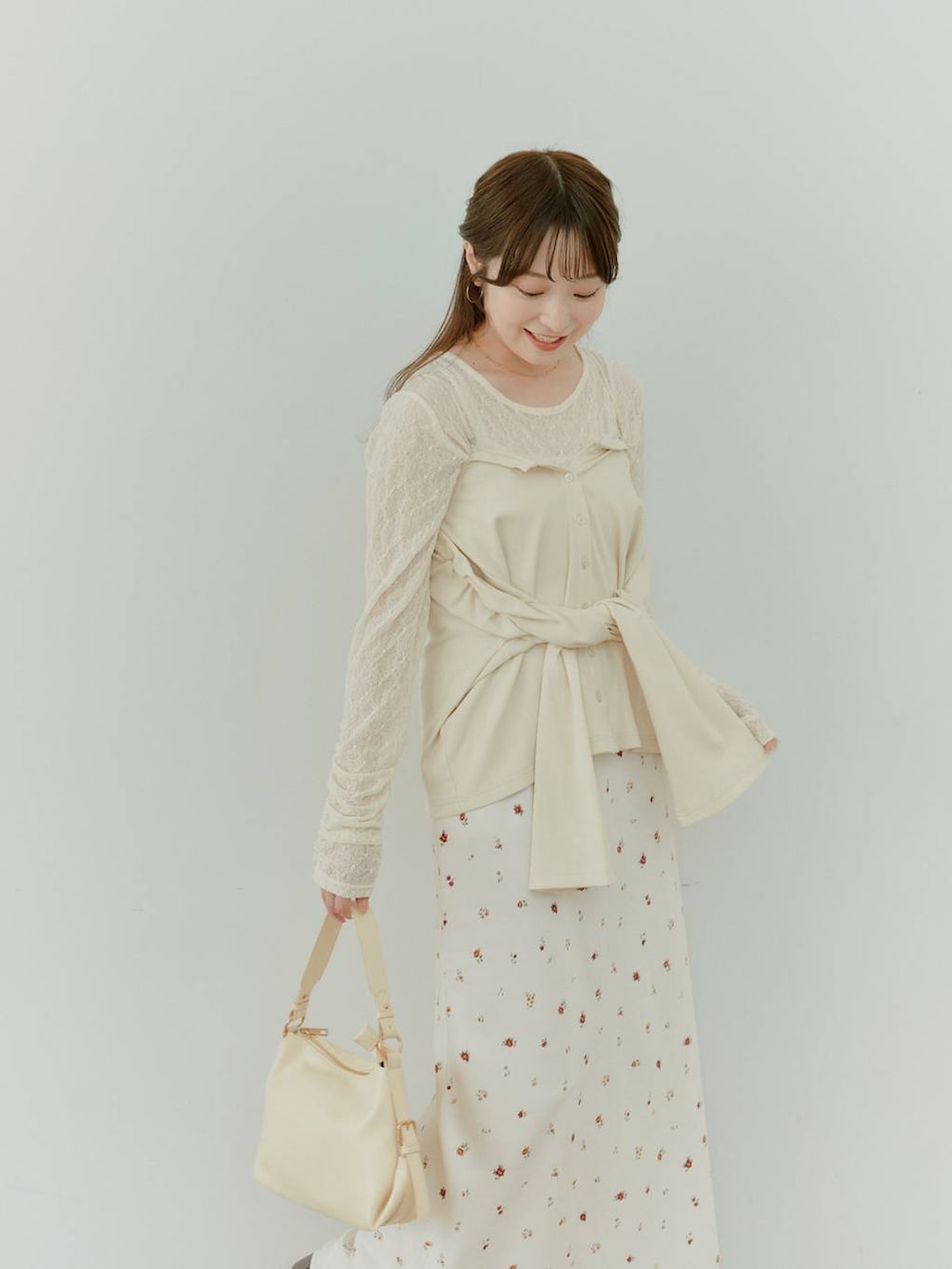 イエロー系のハンドバッグ、ホワイト系のTシャツ/カットソー、ブラウン系のブーツを着用したレディースの秋コーディネートの2枚目の写真